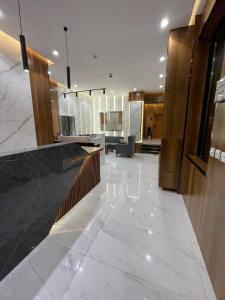 Un vestíbulo con suelo de mármol blanco y un mostrador. en أبها ريجنسي Abha Regency, en Abha 20 fotos más