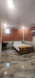 a bedroom with a large bed in a brick wall at The Hills Studio Appartment in Tiruvannāmalai