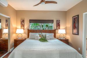 a bedroom with a large bed with two lamps at 1 Acre PRIVATE RESORT 4 bed 3 bath cinema spa in Waikoloa Village +227 photos