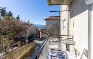a balcony with chairs and a glass table on a building at Awesome Apartment In Novi Vinodolski in Novi Vinodolski