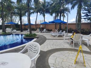 a woman sitting in a chair next to a pool at The Marvelous Suites at Times Square Kuala Lumpur in Kuala Lumpur