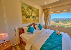 Un dormitorio con una cama con una ventana grande. en Vihani's Western Clouds Ooty by VOYE HOMES, en Ooty