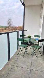 a table and chairs on a balcony with a view at Apartament Szczęśliwy - 14 in Ustronie Morskie