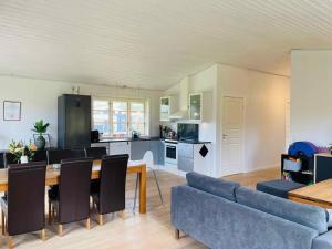 Una cocina y una sala de estar con una mesa y un sofá. en Lovely Cottage With Secluded Garden, en Rødby