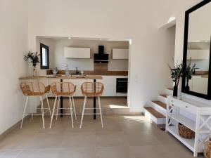 a kitchen with a counter and stools in a room at Maison T3 Élégante Cap Corse - Casa Sublima in Sisco