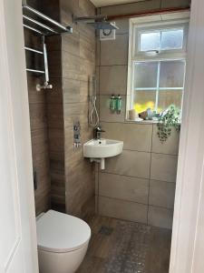 a bathroom with a toilet and a sink and a window at Holly Bank Cottage in Brenchley +8 photos