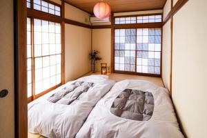 two beds in a room with windows at 伊豆の情景 Izu Nostalgia in Ito