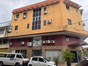 a building with cars parked in front of it at Hotel O Hotel Oriental in Inanam