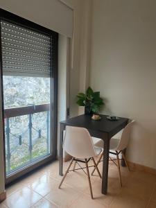a dining room with a table and chairs and a window at Cici Guesthouse in Caminha