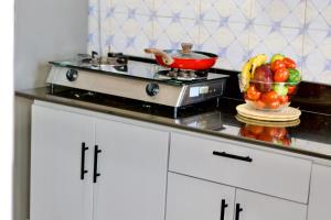 a kitchen counter with a bowl of fruit on a stove at Mwanza city escape in Mwanza