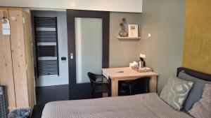 a bedroom with a bed and a table and a desk at Bed & Breakfast De Schans in Makkum