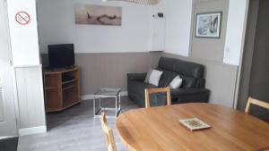 a living room with a table and a couch at Appartement , 500 m de la mer in Le Portel