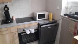 a kitchen with a stove and a microwave at Appartement , 500 m de la mer in Le Portel