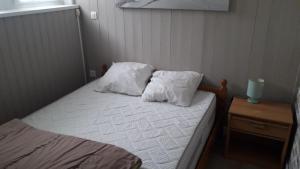 a small bed with two pillows on top of it at Appartement , 500 m de la mer in Le Portel