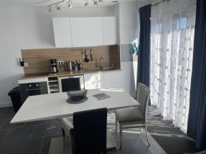 a kitchen with a white table and chairs and a counter at villa méditerranéé in Vias