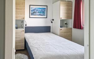 a small bedroom with a bed and wooden cabinets at 1 Bedroom Amazing Apartment In Løkken in Løkken