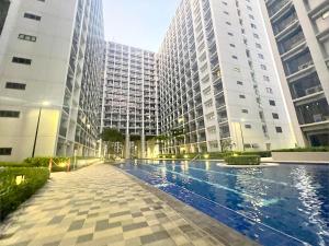 マニラにあるRMD Luxe Staycation by OPMMIの高層ビルが立ち並ぶ街の真ん中にあるプール