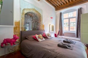 a bedroom with a bed with a pink pig on a table at Le Duplex de Fourvière in Lyon