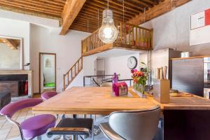 a dining room with a wooden table and purple chairs at Le Duplex de Fourvière in Lyon