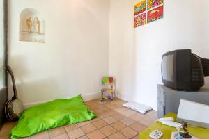 a living room with a tv and a green pillow at Le Duplex de Fourvière in Lyon