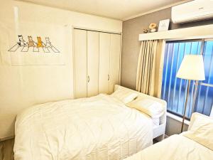 Cama ou camas em um quarto em 편의점까지10초걸리는아늑한아파트 신주쿠2분 역5분 16평 최대4명 부엌침실 장기체류환영