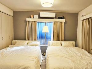 Cama ou camas em um quarto em 편의점까지10초걸리는아늑한아파트 신주쿠2분 역5분 16평 최대4명 부엌침실 장기체류환영