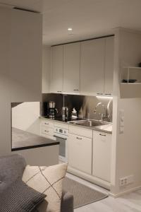 a kitchen with white cabinets and a sink at Huoneisto Villa Kymppi in Kuusamo
