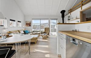 a kitchen and living room with a table and a couch at 3 Bedroom Nice Home In Otterup in Otterup