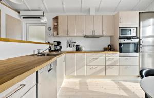 a kitchen with white cabinets and stainless steel appliances at 3 Bedroom Nice Home In Otterup in Otterup