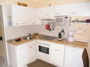 a kitchen with white cabinets and a sink at Ferienwohnung im Ferienpark Falkenstein in Falkenstein