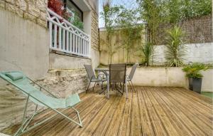 eine Terrasse mit einem Tisch und Stühlen auf einem Holzboden in der Unterkunft Charmante Maison Proche Plage in Royan + 13 Fotos