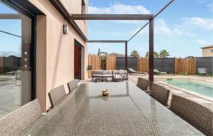 a patio with a table and chairs and a pool at Pet Friendly Home In Les Arcs in Les Arcs sur Argens +12 photos