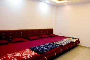 a large bed in a room with red pillows at Devansh Homestay in Ujjain