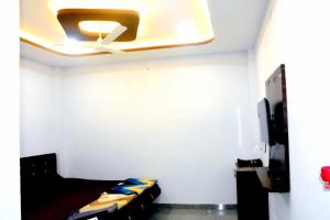 a room with a ceiling fan and a couch at Devansh Homestay in Ujjain