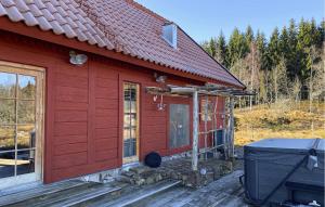 a red house with a front door and a grill at Gorgeous Home In Ydre With Sauna in Hult +25 photos
