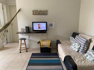 a living room with a couch and a flat screen tv at Apto térreo com garagem, quintal condomínio com portaria 24h in Valparaíso de Goiás +13 photos