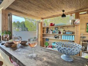two glasses of wine on a table in a kitchen at bastide Uzes à pied Piscine vue imprenable Havre de paix in Uzès