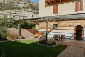 a patio with a table and chairs under an umbrella at Lake House in Nago-Torbole