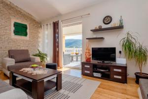a living room with a couch and a tv at Villa Vista Hvar in Jelsa