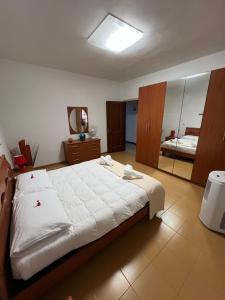 a bedroom with a large bed and a mirror at Casa Maestrale in Gonnesa
