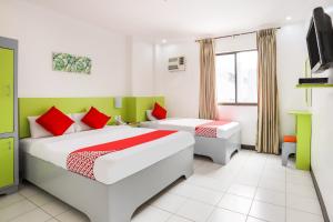 a hotel room with two beds and a tv at OYO 210 Apple Tree Suites in Cebu City +48 photos