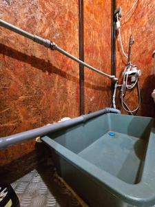 a bath tub sitting next to a wall with a hose at Невелике помешкання зі зручностями та парковкою in Cherkasy