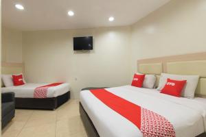 a hotel room with two beds with red pillows at Hotel O Hotel 916 in Batu Caves +34 photos