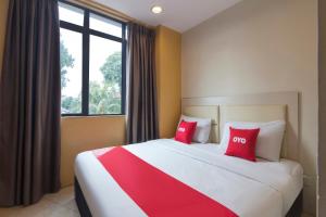 a bedroom with a large bed with two red pillows at Hotel O Hotel 916 in Batu Caves