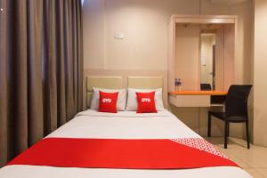 a hotel room with a bed with two red pillows at Hotel O Hotel 916 in Batu Caves