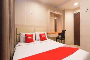 a hotel room with a bed with red pillows at Hotel O Hotel 916 in Batu Caves