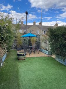 a patio with a table and chairs and an umbrella at Beautiful 3 bedroom house close to Lowestofts south beach in Lowestoft