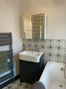 a bathroom with a white sink and a mirror at Beautiful 3 bedroom house close to Lowestofts south beach in Lowestoft +24 photos