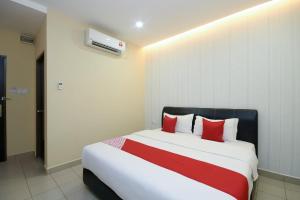 a bedroom with a large bed with red pillows at Hotel O Ys Inn in Miri +44 photos