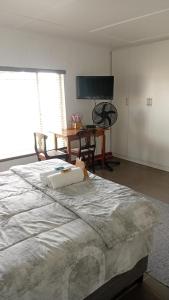 a bedroom with a large bed and a table at LARA'S PLACE in Volksrust